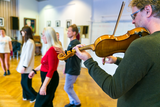 En fiolspelare och människor som dansar