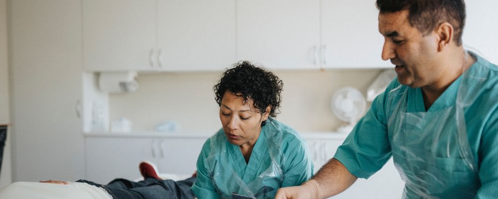 Two colleagues working with patient.